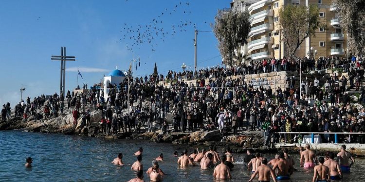 Мужчины сражаются за деревянный крест в водах Греции
